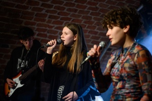 Koncert S.M.ROCK: Uczennice i uczniowie na scenie wykonujący piosenkę przed publicznością