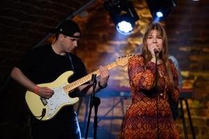 Koncert S.M.ROCK: na scenie śpiewająca uczennica i grający na gitarze uczeń