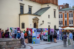 Wystawa: Konfrontacje Plakatu Studenckiego - Plakaty na tarnowskim Rynku oglądane przez publiczność wernisażu.