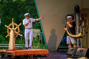 Szanty na Starówce - 26.08.2023 - Rozpoczęcie drugiego spotkania z szantami. Na scenie Ryszard Żądło wita publiczność.