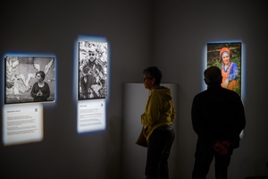 Wystawa: Powroty - Publiczność wernisażu oglądająca fotografie.