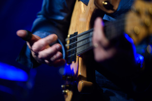 Koncert: Wojtek Pilichowski Band - Scena w Piwnicach TCK, Wojtek Pilichowski  gra na gitarze basowej.