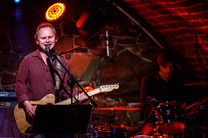 Koncert: Zaduszki - Paweł Mazur (gospodarz wieczoru) śpiewa i gra na gitarze.