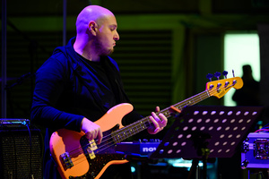 Koncert: 30-lecie S.M.Rock - Scena, występ nauczycieli S.M.Rock - Grzegorz Nosek gra na gitarze basowej.