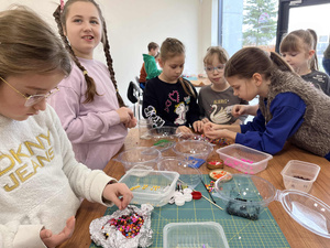 Ferie w Domu Kultury Westerplatte - Na fotografii przedstawione są dzieci uczestniczące w zajęciach integracyjnych, rozwijających umiejętności i kreatywność poprzez zabawę, ruch oraz tworzenie prac plastycznych.