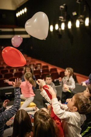 Filmowe ferie w kinie Marzenie - Na fotografii widzimy grupę dzieci na scenie przed ekranem, podczas animacji poprzedzających projekcje filmowe w ramach cyklu "Filmowe ferie".