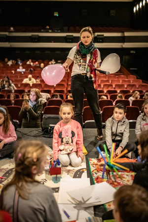 Filmowe ferie w kinie Marzenie - Na fotografii widzimy grupę dzieci na scenie przed ekranem, podczas animacji poprzedzających projekcje filmowe w ramach cyklu "Filmowe ferie".
