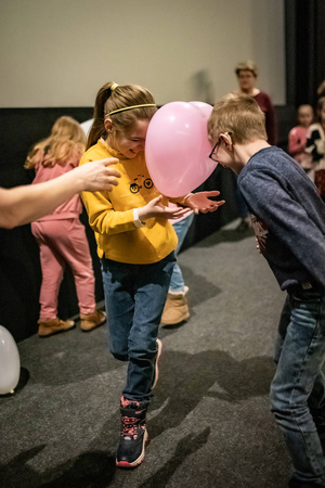Filmowe ferie w kinie Marzenie - Na fotografii widzimy grupę dzieci na scenie przed ekranem, podczas animacji poprzedzających projekcje filmowe w ramach cyklu "Filmowe ferie".