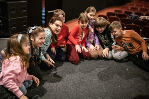 Filmowe ferie w kinie Marzenie - Na fotografii widzimy grupę dzieci na scenie przed ekranem, podczas animacji poprzedzających projekcje filmowe w ramach cyklu "Filmowe ferie".