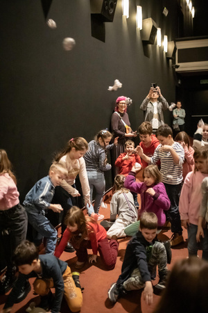 Filmowe ferie w kinie Marzenie - Na fotografii widzimy grupę dzieci na scenie przed ekranem, podczas animacji poprzedzających projekcje filmowe w ramach cyklu "Filmowe ferie".