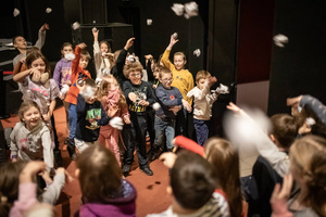 Filmowe ferie w kinie Marzenie - Na fotografii widzimy grupę dzieci na scenie przed ekranem, podczas animacji poprzedzających projekcje filmowe w ramach cyklu "Filmowe ferie".