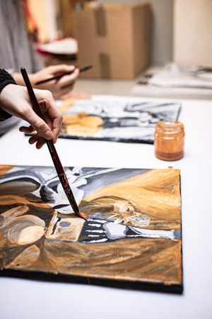 Artystyczne Ferie - tydzień I - Na zdjęciu przedstawione są dzieci uczestniczące w warsztatach plastycznych, skupione na malowaniu i rysowaniu. Widoczne są również osoby prowadzące, które instruują i inspirują młodych uczestników, zachęcając ich do twórczej ekspresji