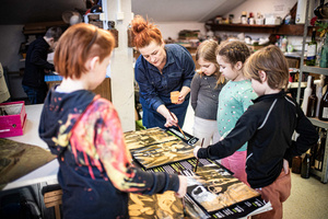Artystyczne Ferie - tydzień I - Na zdjęciu przedstawione są dzieci uczestniczące w warsztatach plastycznych, skupione na malowaniu i rysowaniu. Widoczne są również osoby prowadzące, które instruują i inspirują młodych uczestników, zachęcając ich do twórczej ekspresji