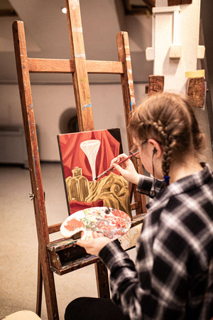 Artystyczne Ferie - tydzień I - Na zdjęciu przedstawione są dzieci uczestniczące w warsztatach plastycznych, skupione na malowaniu i rysowaniu. Widoczne są również osoby prowadzące, które instruują i inspirują młodych uczestników, zachęcając ich do twórczej ekspresji