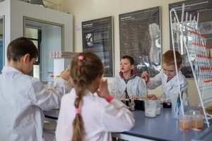 Naukowe Ferie w Pasażu Odkryć - Na zdjęciu przedstawieni są uczestnicy – dzieci i młodzież – zaangażowani w aktywności edukacyjne w różnych pracowniach naukowych, takich jak chemiczna, stolarska, planetarium oraz informatyczna. Widoczne są sceny, gdzie uczą się i przeprowadzają eksperymenty pod nadzorem instruktorów.