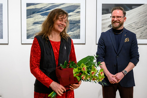 Wernisaż wystawy Autoportret Naturalnie - Inez Baturo z bukietem kwiatów i Marcin Dąbek.