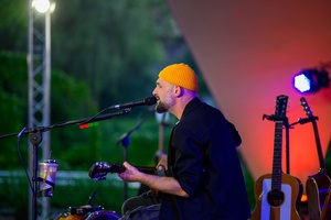 Koncert: Skubas - Duet Akustycznie - Na scenie grający na gitarze i śpiewający Skubas