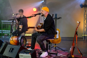 Koncert: Skubas - Duet Akustycznie - Na amfiteatralnej scenie grający na gitarach i śpiewający Marcin Grabiński i Skubas