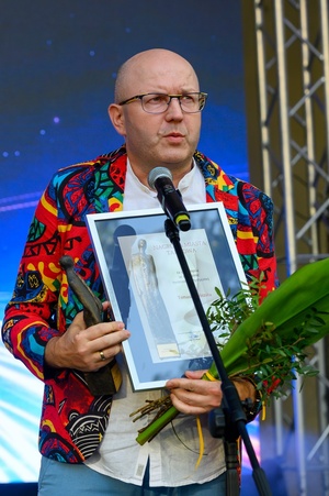 ZDEARZENIA 2024 - Gala Nagród Miasta Tarnowa - Na scenie laureat nagrody fotograf Tomasz Sobczak wygłaszający mowę dziękczynną