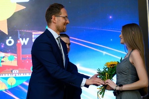 ZDEARZENIA 2024 - Gala Nagród Miasta Tarnowa - Na scenie prezydent Jakub Kwaśny wręczający kwiaty Oliwii Miś