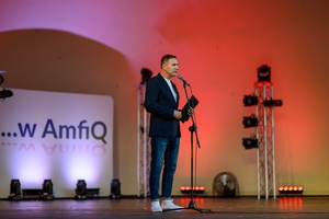 Koncert: "Ballady na głos i gitarę" - Łucja Kania - Na amfiteatralnej scenie Tomasz Kapturkiewicz zapowiadający występ Łucji Kani