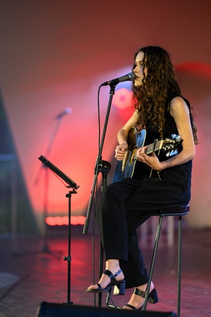 Koncert: "Ballady na głos i gitarę" - Łucja Kania - Na scenie śpiewająca i grająca na gitarze Łucja Kania