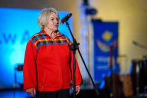 Koncert zespołu Wołosatki na 100-Lecie Oddziału PTTK "Ziemi Tarnowskiej" - Na amfiteatralnej scenie Prezes Zarządu tarnowskiego oddziału PTTK Barbara Jarocka otwierająca koncert