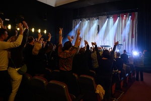 Koncert: Kasia Lins - Publiczność na stojąco podczas bisów, w tle na scenie zespół Kasi Lins