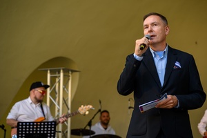 Koncert Chóralne Majówki: Chór GOS.pl - Na scenie dyrektor TCK Tomasz Kapturkiewicz zapowiadający koncert Chóru GOS.pl