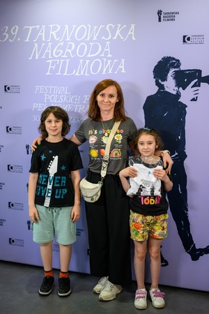 39. TNF: Dzień 3 (1.06.2025) - W hallu kina mama z dwójką dzieci fotografująca się na ściance 39. TNF