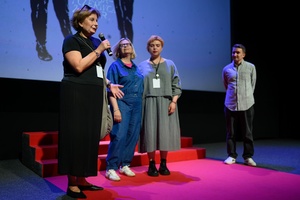 39. TNF: Dzień 4 (2.06.2025) - Na scenie Marzenia Małgorzata Imielska, reżyserka filmu "Posłuchaj, co chcę ci powiedzieć" zapraszająca widzów na seans. W tle główna bohaterka filmu Gosia z mamą i Kuba Armata