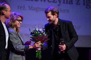 39. TNF: Gala Wręczenia Nagród (7.06.2025) - Na scenie od lewej: jurorzy 39. TNF Łukasz M. Maciejewski i Anna Jadowska wręczający statuetkę Grand Prix - Maszkarona i kwiaty Magnusowi von Horn za film "Dziewczyna z igłą"