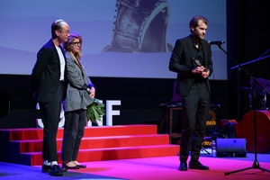 39. TNF: Gala Wręczenia Nagród (7.06.2025) - Na scenie przemawiający do widzów nagrodzony Magnus von Horn oraz jurorzy 39. TNF Łukasz M. Maciejewski i Anna Jadowska