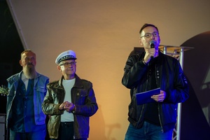 Szanty na Starówce: Aqua Marina, Mechanicy Szanty - Na scenie Tomasz Kapturkiewicz gratulujący Mechanikom Szanty jubileuszu 40-lecia