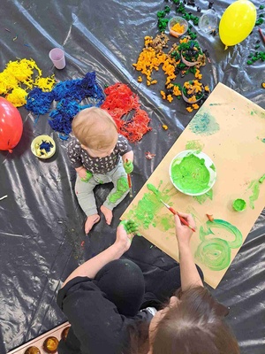 Warsztaty sensoplastyczne - Uczestnik warsztatów wraz z opiekunem malują farbami