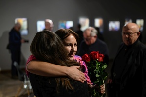 Wystawa: Nim zgaśnie Słońce - Autorka Małgorzata Sikora przyjmująca gratulacje i kwiaty.