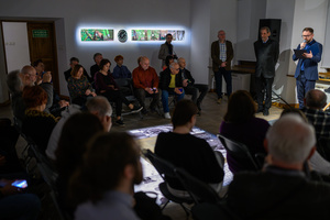 Wystawa: Rozważania nad istotą czasu - Od prawej: Marcin Dąbek podczas przemowy na otwarciu, obok autor wystawy Marek Kucharczyk.- i prowadzący spotkanie Tomasz Sobczak, a na pierwszym planie publiczność.