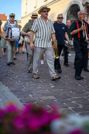 Starówka Jazz Festival – Enerjazzer / Slavia Dixieland Band - Muzycy jazzowi grający na instrumentach podczas radosnego marszu z Rynku do Amfiteatru w Tarnowie w otoczeniu mieszkańców.