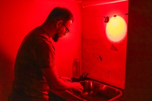 Warsztaty fotograficzne: Guma dwuchromianowa - Uczestnik w trakcie płukania nad zlewem w świetle podczerwonym.